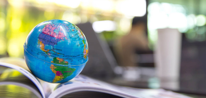 Miniature globe placed on an open textbook | Russell-Cooke charity law and nonprofits team helping charities and nonprofits navigate the legal and regulatory challenges of working internationally