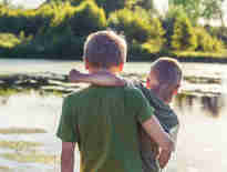 Two brothers in arms in front of a lake. Brain Injury Claims Solicitors