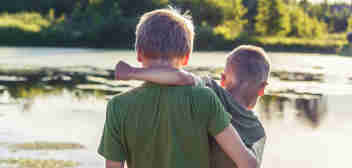 Two brothers in arms in front of a lake. Brain Injury Claims Solicitors