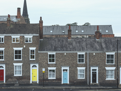 Georgian townhouses in the UK with colourful painted doors and a church spire in the background.Renters Reform Bill update —the future landscape of private renting