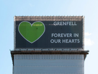 Grenfell Tower Inquiry Phase 2 Report findings – Legal support from Russell-Cooke for Grenfell victims. Image of a banner covering the Grenfell Tower. The banner has a large green heart and the words